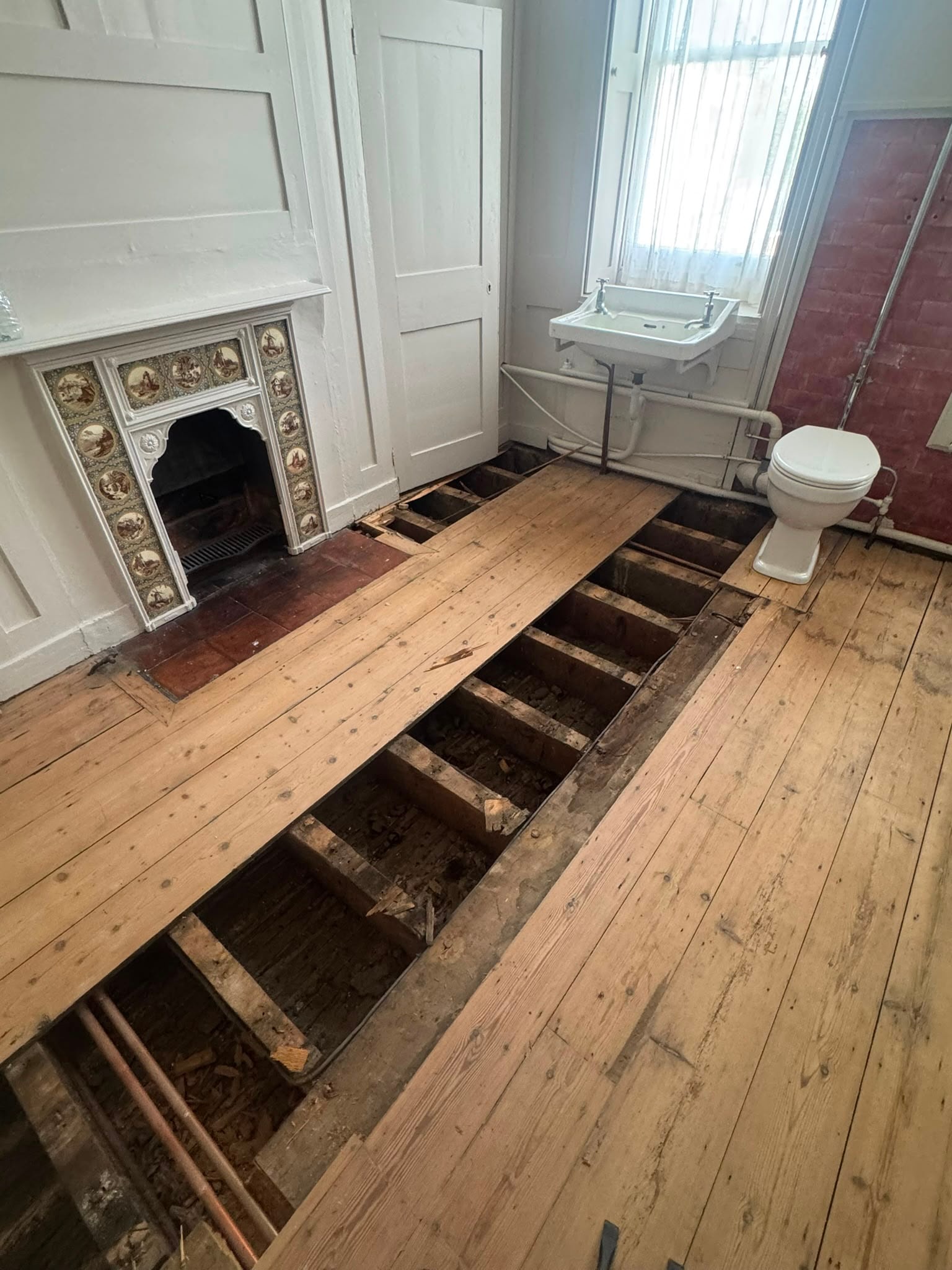 Original floorboards lifted during the Chertsey bathroom strip-out.