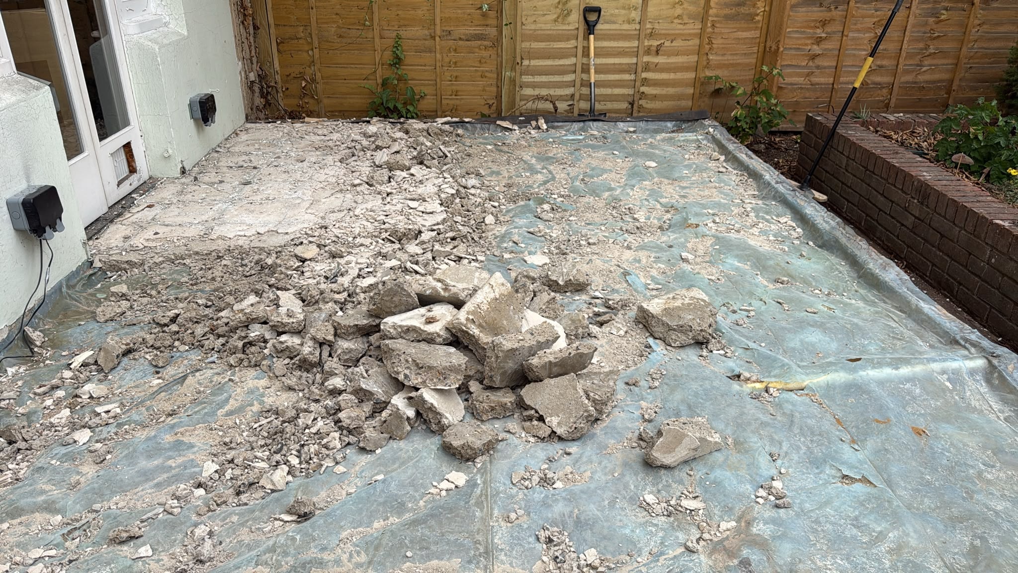 Concrete conservatory floor slab being broken out in Reigate